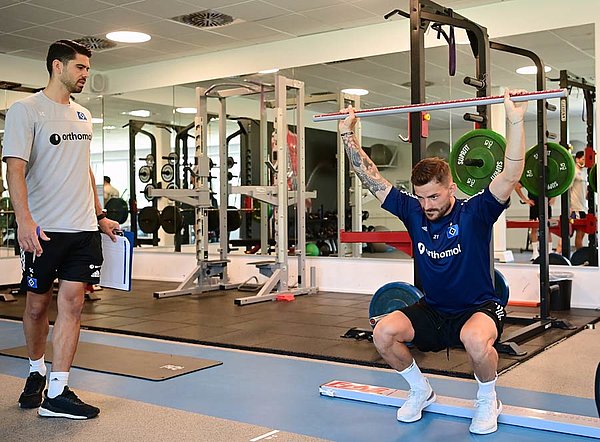 Kapitän Tim Leibold bei einem der zahlreichen Beweglichkeitstests. Reha-Trainer Sebastian Capel achtet auf die genaue Ausführung.